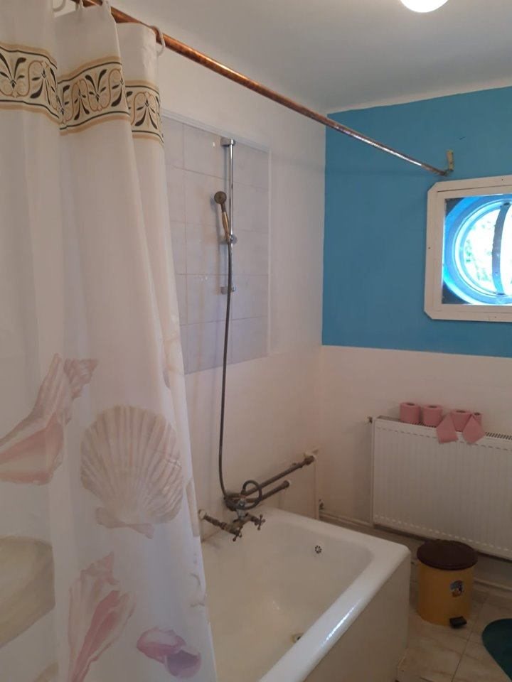 Baia casei cu cada, perdea de dus si faianta albastra